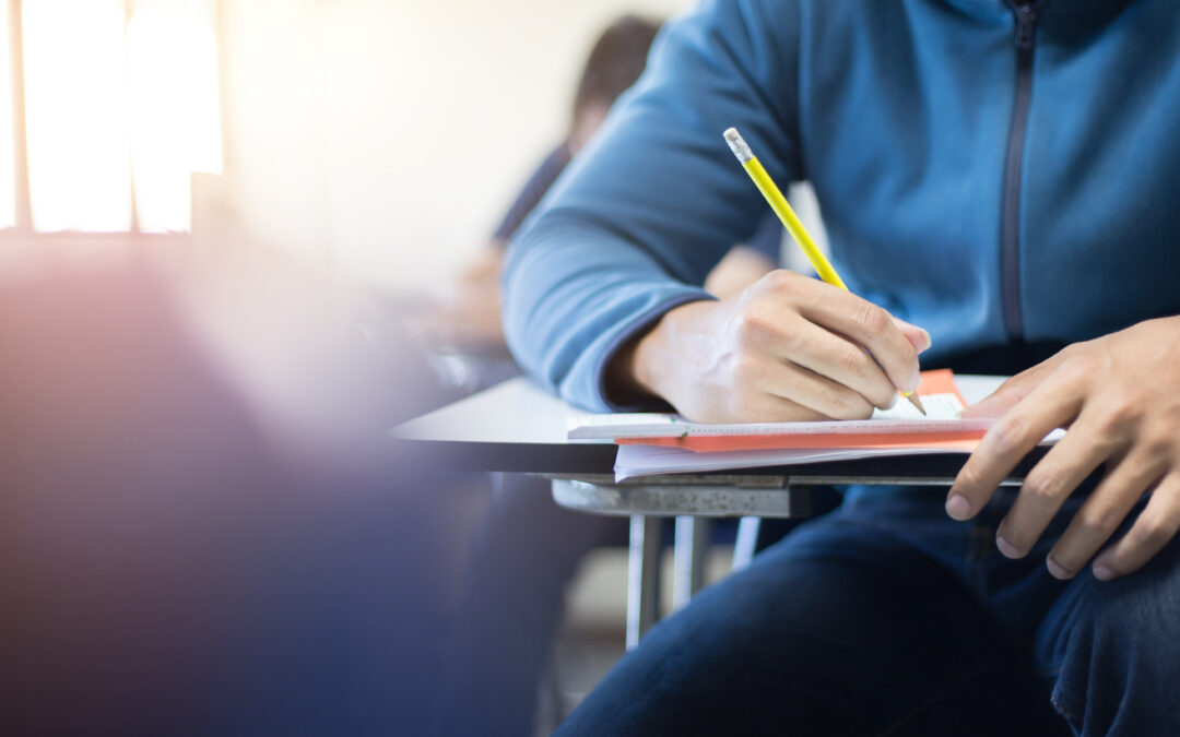 student writing at a desk