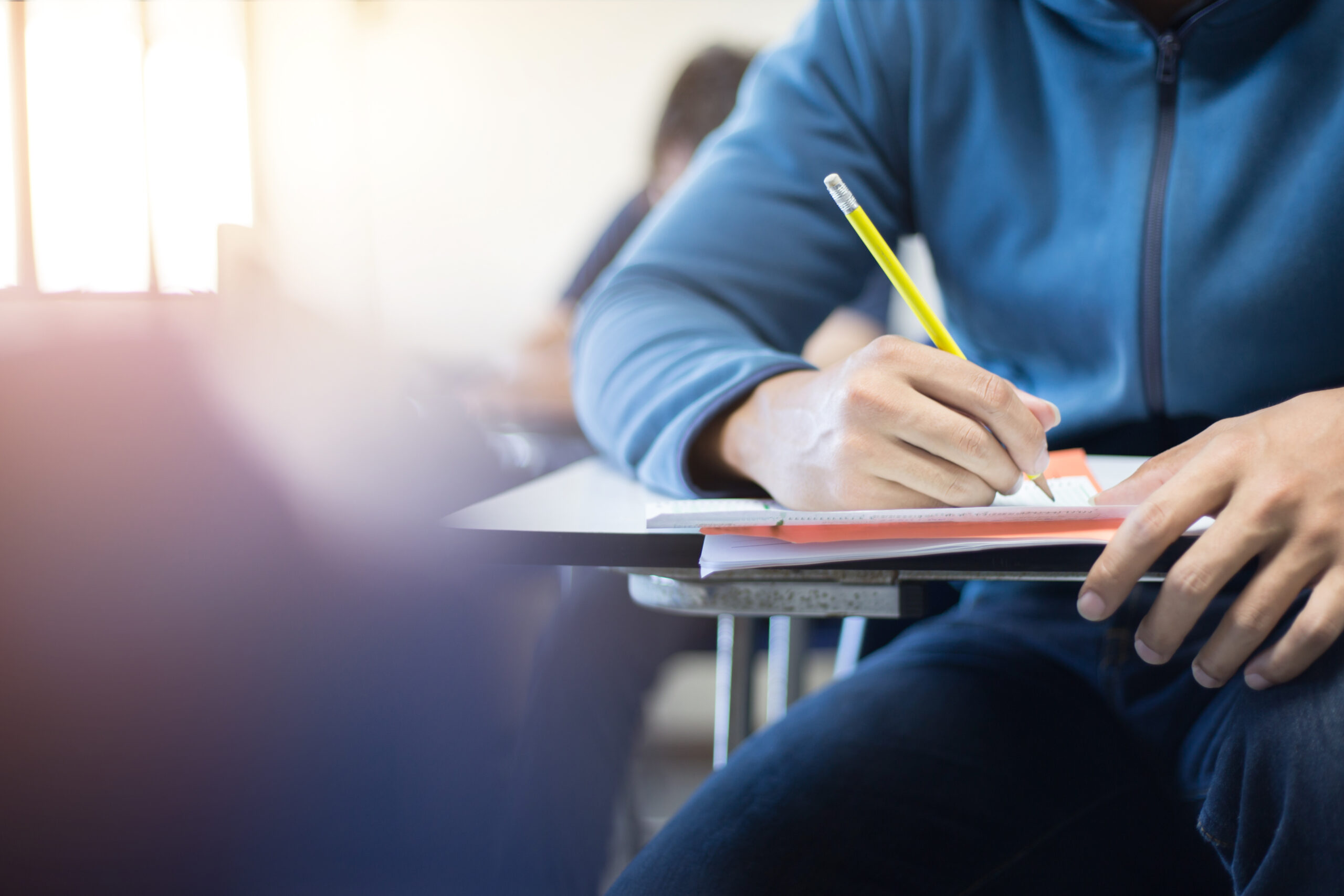 student writing at a desk