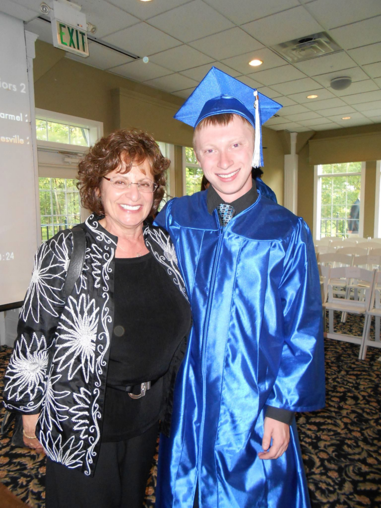 Denny Leinhos at graduation, dressed in cap and gown